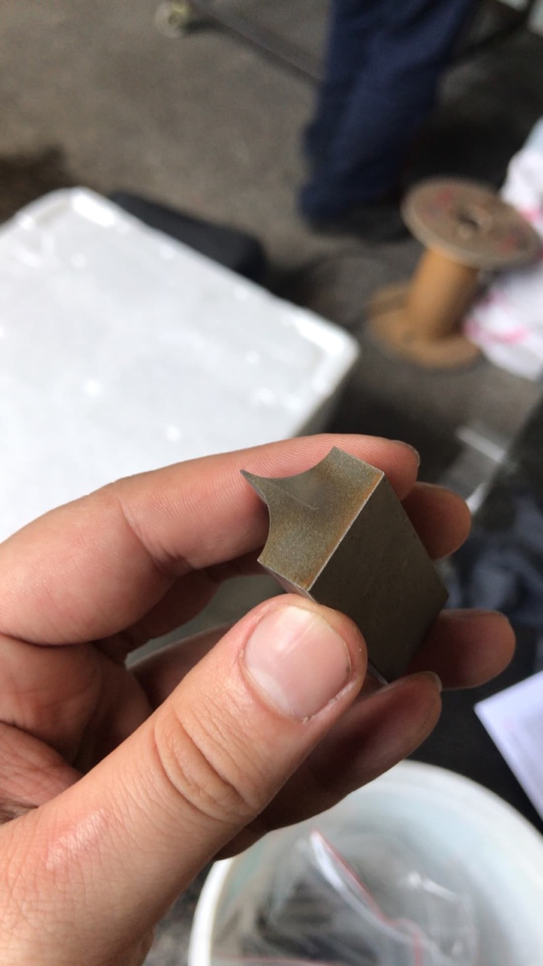 Manufactured cutting blade in hand showing precision-machined finish and final geometry